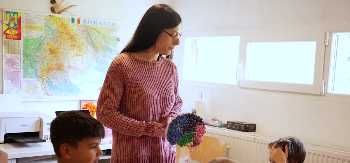 Damaris ensinando crianças na sala do programa educacional